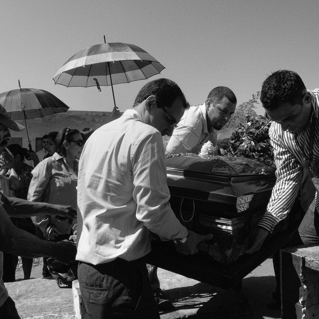 Family and friends carry the coffin to the grave my dad